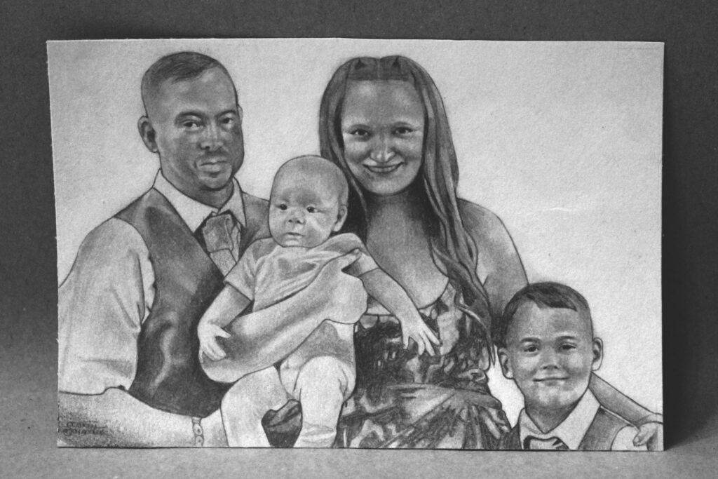 A detailed pencil drawing of a family portrait. The image features a man in a suit holding a baby, a woman in a dress smiling beside him, and a young boy in a formal outfit on the right. The background is plain, highlighting the subjects.