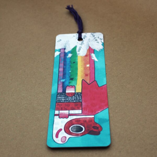 A vibrant bookmark featuring a colorful design, with a tassel, showcasing Super Poppy the guinea pig farting a rainbow.