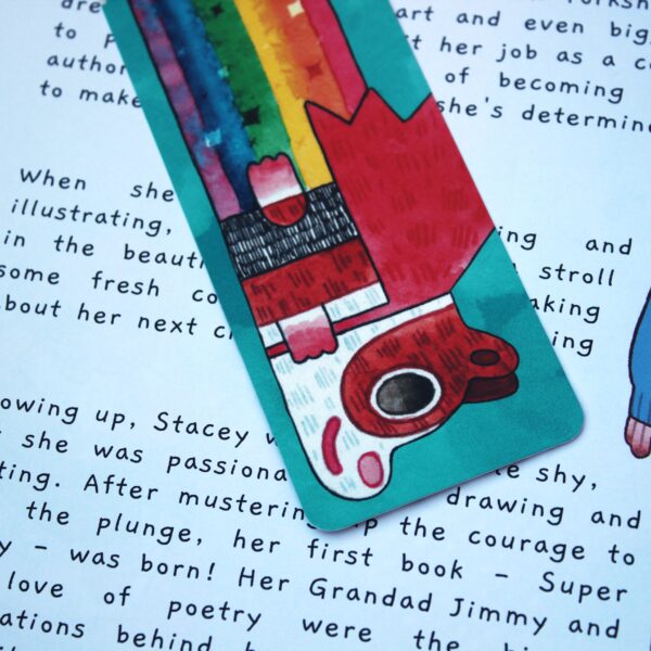 A book with a colorful rainbow bookmark. The bookmark features a super poppy guinea pig.