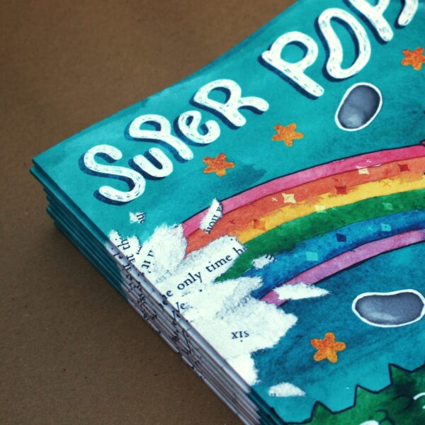 Stack of Super Poppy books topped with a rainbow and guinea pig, depicting a vibrant children's book by Stacey Saunders.